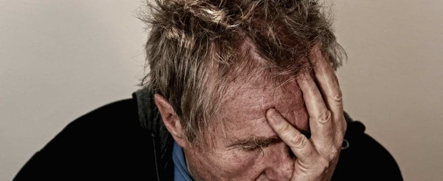 man with head in hands suffering from burnout