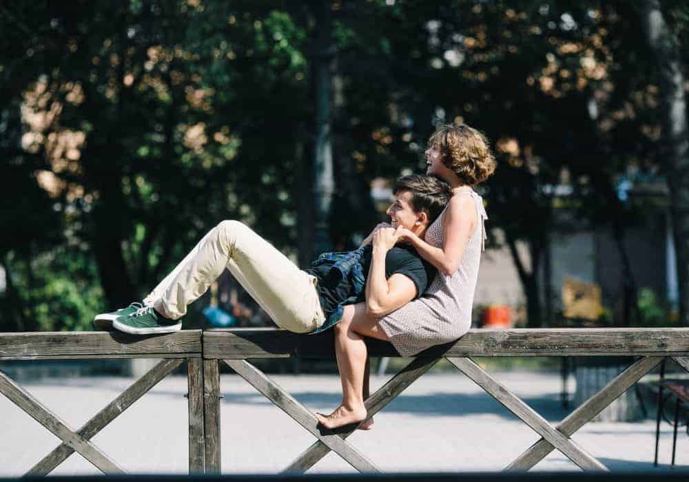 Young Men young couple on fence seeking marriage and family