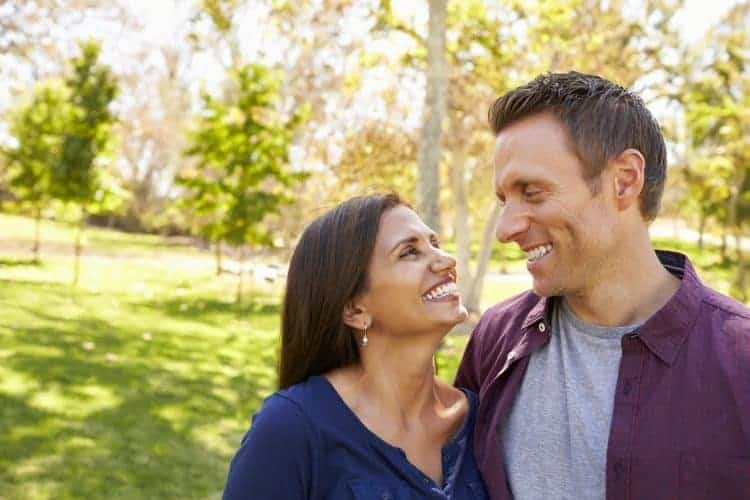 happy mixed race couple in park looking at each ot PM9RL6U