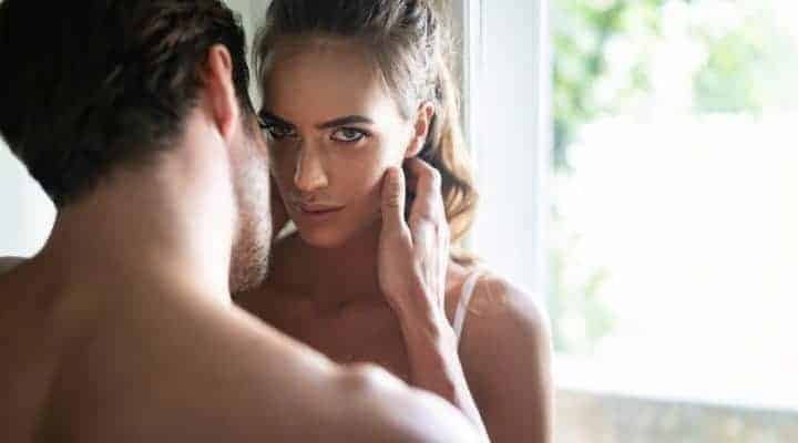man touches woman's face