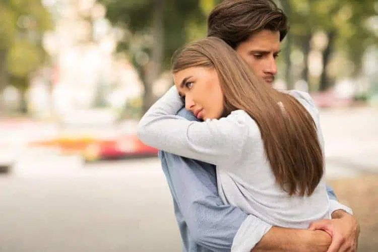 sad guy and girl hugging feeling unloved standing YFJX83U end a relationship