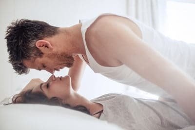 Intimate young couple during foreplay in bed