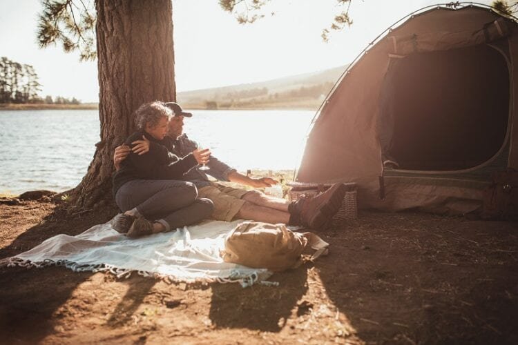 loving senior couple camping near a lake PWY5PRA