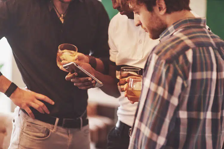 Group of multietnic friends guys with glasses of whiskey. Concept party, bachelor party barbershop.