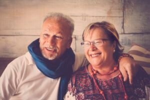 Two senior couple smiling happy at home. Vintage filter and fashion clothes for two beautiful elderly man and woman