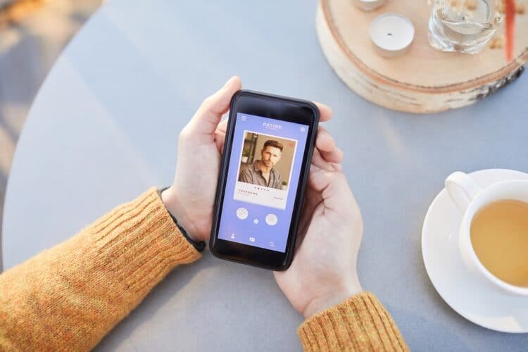 Close-up of man using his mobile phone for online dating while sitting at the table