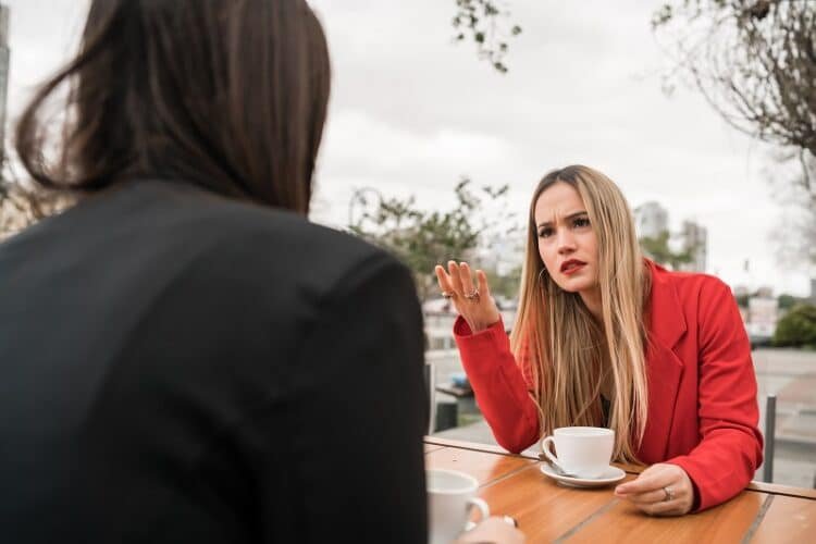 Portrait of two angry friends having a serious conversation and discussing while sitting at coffee shop. Friendship concept. Emotional manipulators.