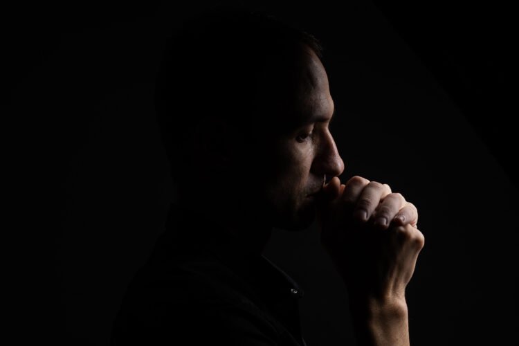 Male Silence: Psychological Insights and Implications for Couples 3 a man with his hand in his mouth - Male Silence