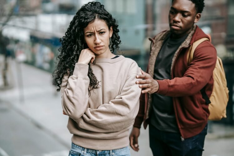 Multiracial couple arguing with each other in street due to common relationship mistakes