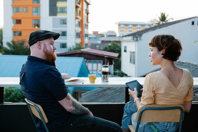 Casual man and woman chatting and resting on terrace